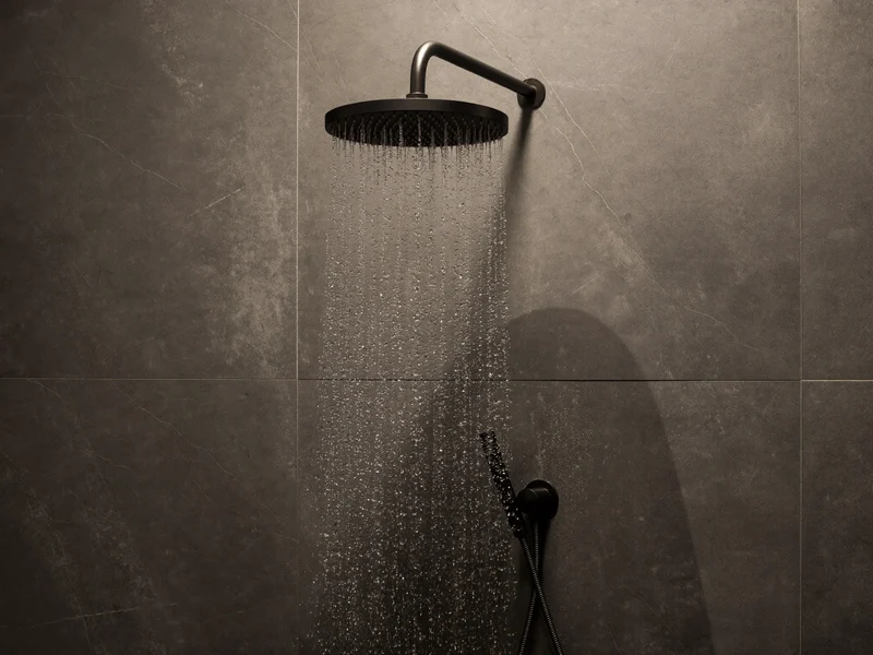 Mattschwarze Regenbrause mit Thermostatmischer an grauer Fliesenwand, illustrativ
